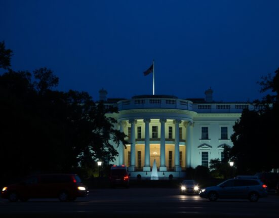 White House exterior on a clear evening with security presence, representing the target of the assassination attempt.