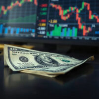 US dollar banknote with financial charts in background, representing currency crisis analysis