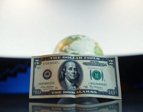 US dollar banknote with globe and stock chart background