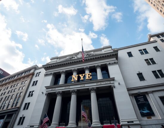 New York Stock Exchange building facade on Wall Street under partly cloudy sky