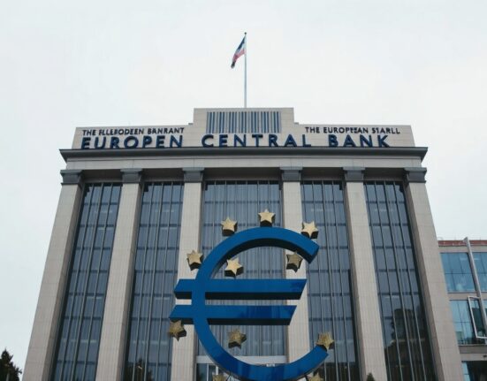 European Central Bank headquarters in Frankfurt with Euro symbol in foreground on a cloudy day
