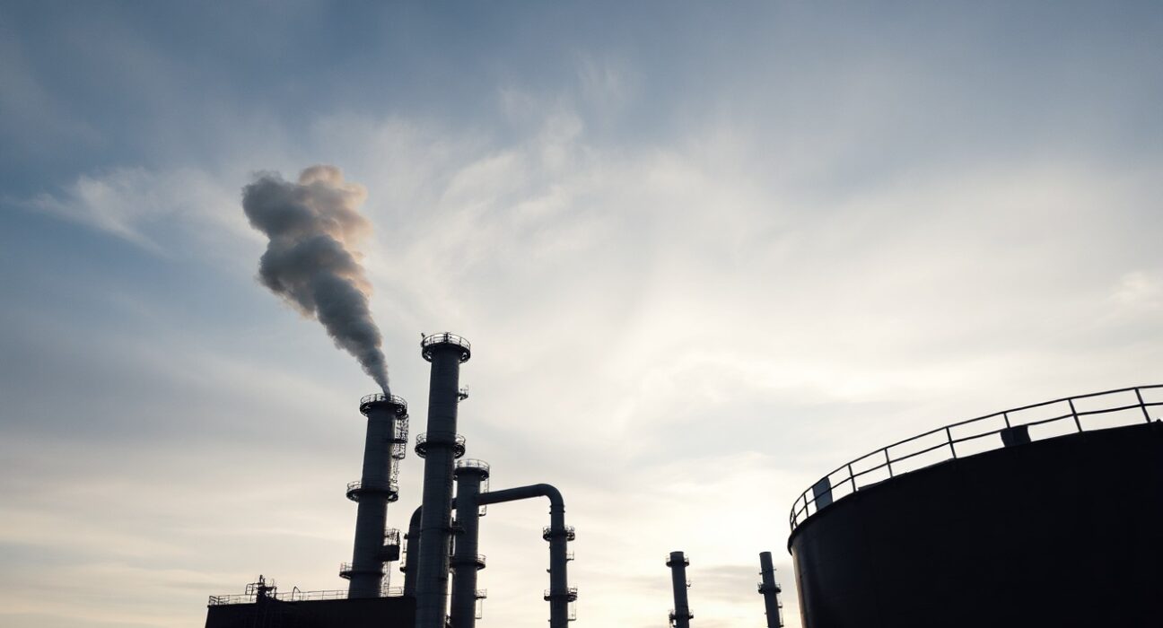 Oil refinery at dusk representing global crude supply disruption