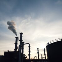 Oil refinery at dusk representing global crude supply disruption