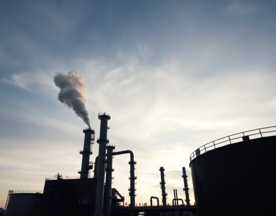 Oil refinery at dusk representing global crude supply disruption