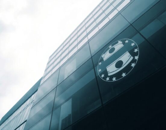 European Central Bank headquarters in Frankfurt on a cloudy day, with oil barrel reflection symbolizing rate hike risk.
