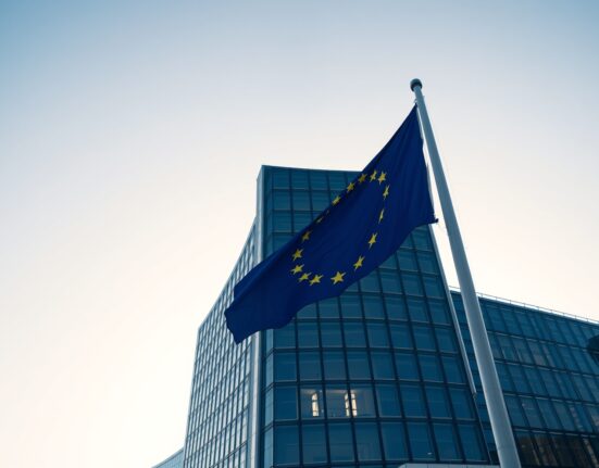European Commission headquarters in Brussels on a clear morning with EU flag in foreground