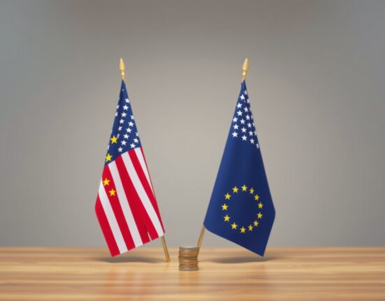 EU and US flags on table with Euro and Dollar coins in foreground, representing EUR/USD currency pair analysis.