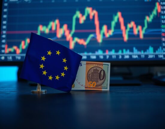 Euro banknote and European Union flag on a desk with financial charts in the background