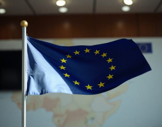 EU flag waving with blurred diplomatic background representing euro gains after ceasefire