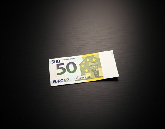 A single Euro banknote on a dark surface representing currency market movements.
