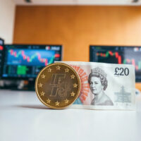 Euro coins and British Pound banknotes on a desk, symbolizing EUR/GBP exchange rate focus