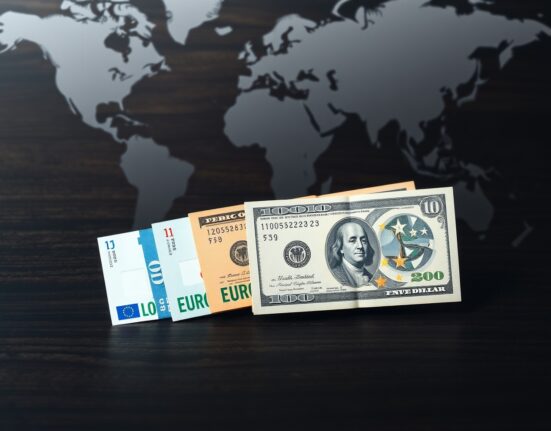 Euro and US Dollar banknotes on a surface, representing currency exchange rate fluctuations.