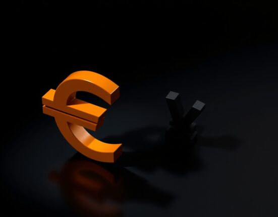 Euro symbol dominating a smaller Japanese yen symbol on a dark reflective surface.