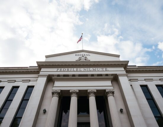 Federal Reserve building in Washington, D.C., under cloudy sky, representing monetary policy uncertainty.