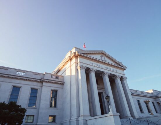 Federal Reserve building in Washington, D.C., under a clear sky, symbolizing monetary policy decisions.