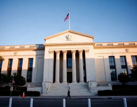 Federal Reserve building in Washington, D.C., under a clear sky.