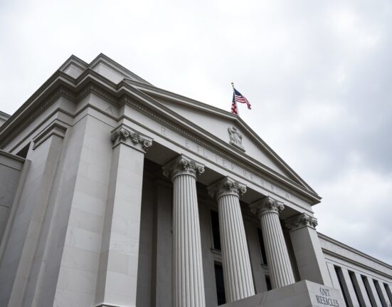 Federal Reserve building exterior under overcast sky, representing patient monetary policy and steady interest rates amid geopolitical uncertainty.