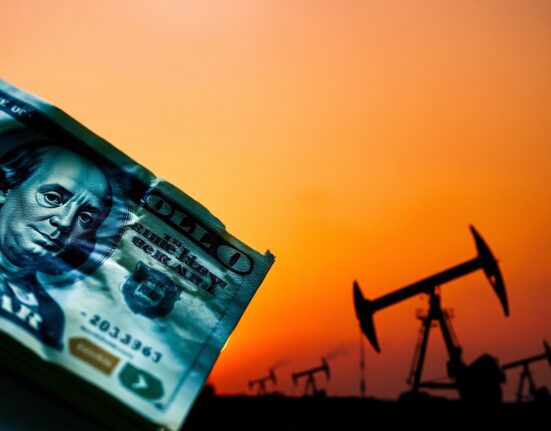 US Dollar banknote and oil pumpjack silhouette representing forex and energy market volatility