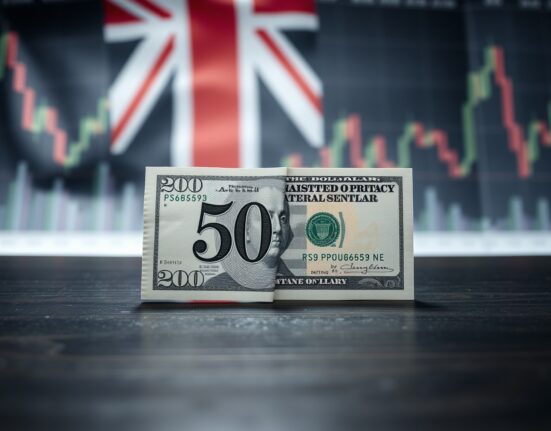 GBP and USD banknotes on desk with financial charts background