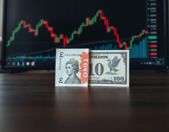 British Pound and US Dollar banknotes on a trader's desk with a chart in the background.
