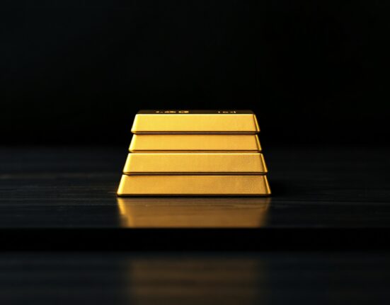 Stacked gold bars on a dark surface with soft lighting, representing gold price near $4,300.
