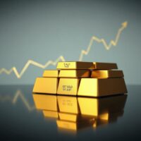 Gold bars stacked on a dark surface, representing the bullish gold price forecast near $4,400.