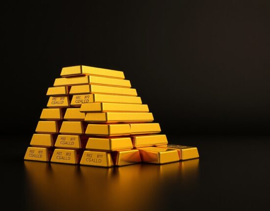 Stack of polished gold bullion bars under studio lighting representing rising gold prices.