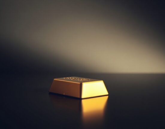 Gold bar on reflective surface with soft lighting representing precious metals market