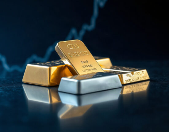Gold and silver bullion bars on a dark surface with a price chart in the background