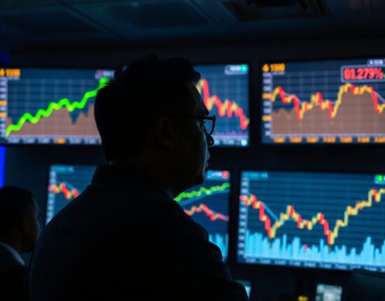 Trader observing gold price surge and US Dollar decline on trading floor screens