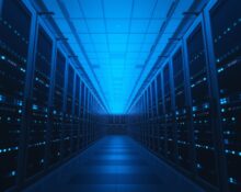 Interior of a modern data center with glowing blue server racks representing AI inference infrastructure.