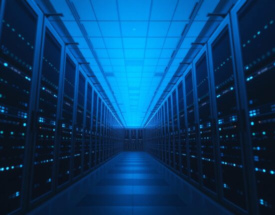 Interior of a modern data center with glowing blue server racks representing AI inference infrastructure.