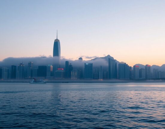 Hong Kong skyline at dusk with fog, representing geopolitical risks weighing on financial outlook according to Standard Chartered.