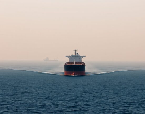 Large oil tanker sailing through the narrow Strait of Hormuz, a critical global energy chokepoint.