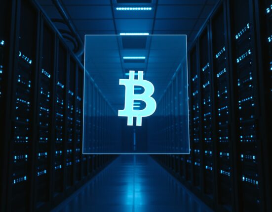 Interior of a modern data center with blue server lights and a faint Bitcoin symbol projection