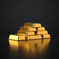 Stack of polished gold bars on a dark reflective surface, representing the latest gold price increase in India.