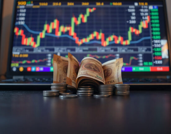 Indian rupee banknotes and coins on a desk with a chart in background