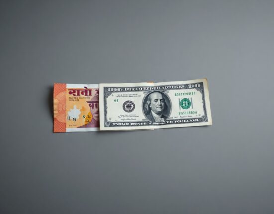Indian Rupee and US Dollar banknotes arranged on a neutral background representing forex market dynamics