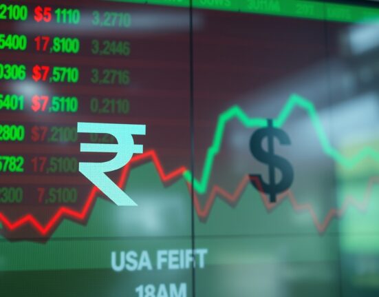 Close-up of a digital trading board showing the Indian rupee and US dollar symbols with market data in the background.