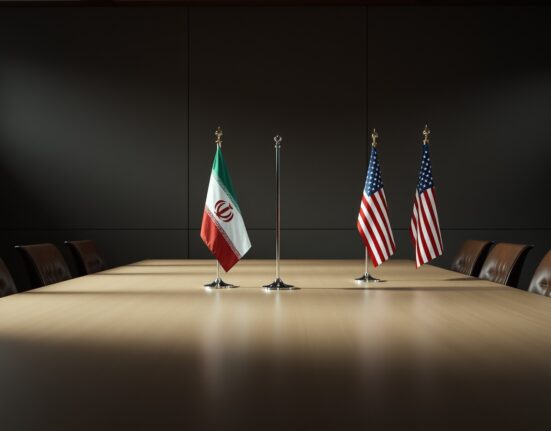 Iranian and American flags in a dimly lit diplomatic meeting room, representing ongoing negotiations.