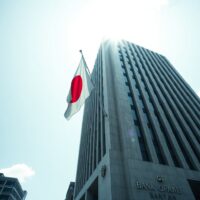 Bank of Japan headquarters in Tokyo on a clear day, symbolizing the central bank's role in setting monetary policy.