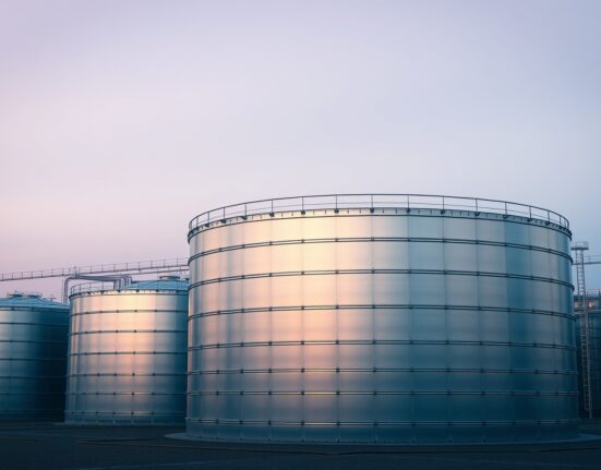 Industrial oil storage tanks representing strategic petroleum reserves release impacting WTI crude prices.