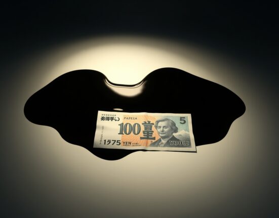 Japanese yen banknote partially submerged in oil, symbolizing energy-driven currency weakness.