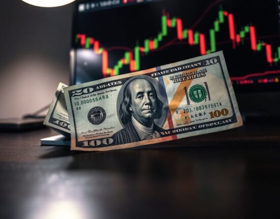 Japanese Yen and US Dollar banknotes on a desk with a forex chart in the background.