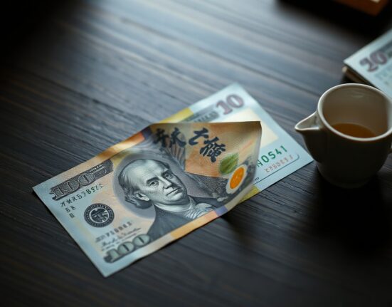 Japanese Yen and US dollar banknotes on a desk with a teacup, representing forex market analysis.