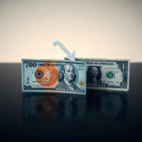 Japanese yen and US dollar banknotes arranged on a reflective surface, with yen slightly lower, symbolizing depreciation