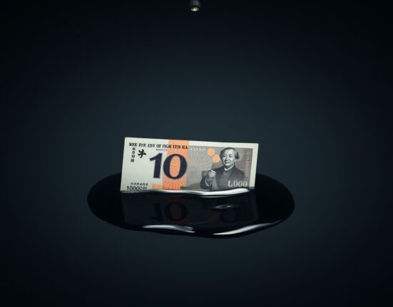 Japanese yen banknote partially submerged in oil, symbolizing currency pressure from high energy costs.
