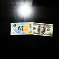Japanese yen and US dollar banknotes on a dark surface, representing currency exchange and forex market analysis.