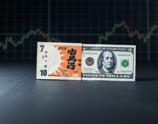 Japanese Yen and US Dollar banknotes on a dark background with chart grid lines.