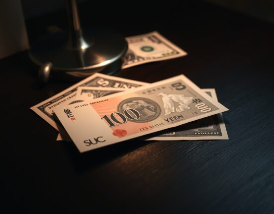 Japanese yen banknote on desk with US dollar in background, representing forex market analysis
